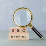 Conceptual of seo analysis and business. with wooden blocks with words on it, magnifying glass on sage color background side view. horizontal image